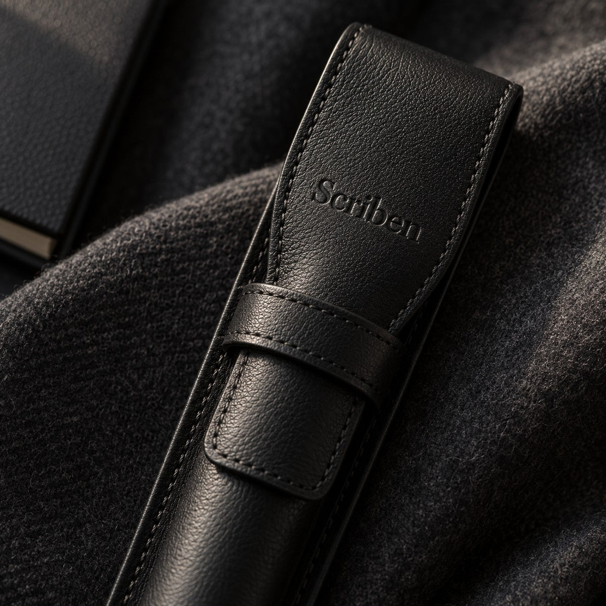 Close-up of the debossed Scriben logo and hand stitching on the leather pen case